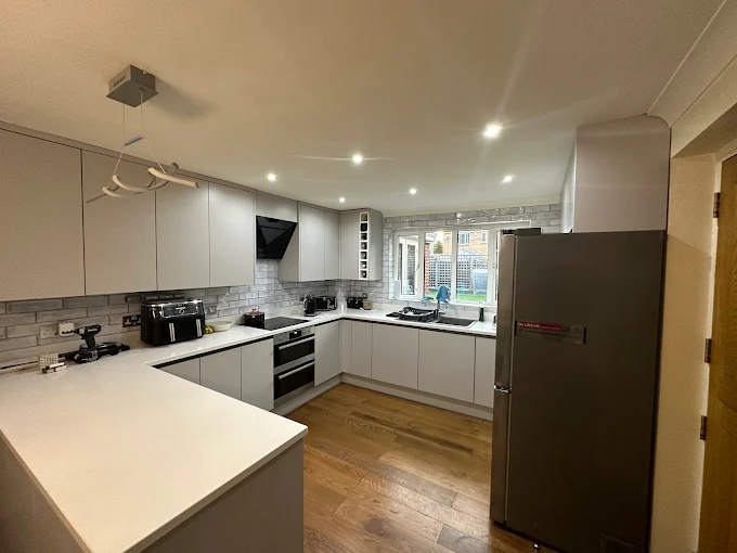 A luxury bespoke kitchen with matte black cabinetry, marble island and brass accents