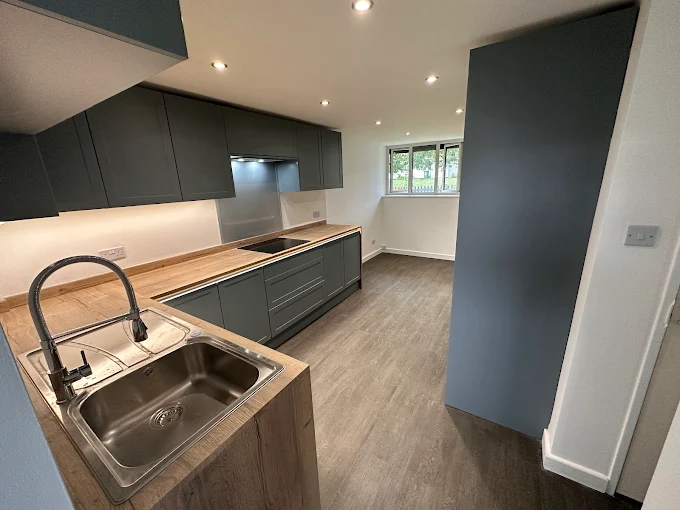 Slate graphite handleless kitchen with wood worktop and under-cabinet strip lighting